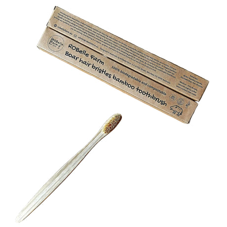 Bamboo toothbrush with packaging on a beige background