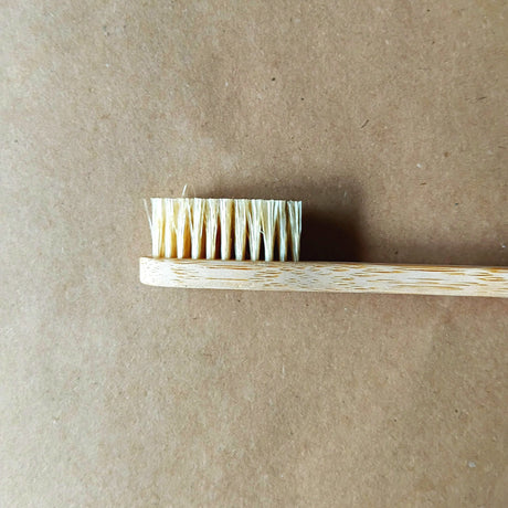 Bamboo toothbrush with bristles on a brown background
